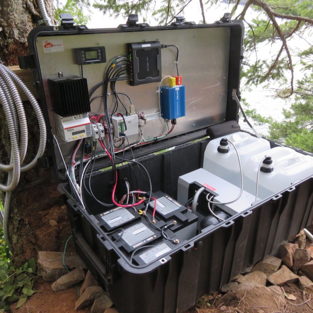 Rugged power and control enclosure with batteries, relay modules, and fluid reservoirs mounted outdoors